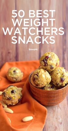 a bowl filled with cookies sitting on top of an orange cloth next to a wooden table