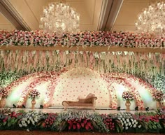 an elaborate stage decorated with flowers and chandeliers for a wedding or special event