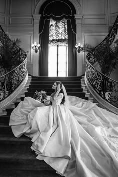 a woman in a wedding dress sitting on some stairs