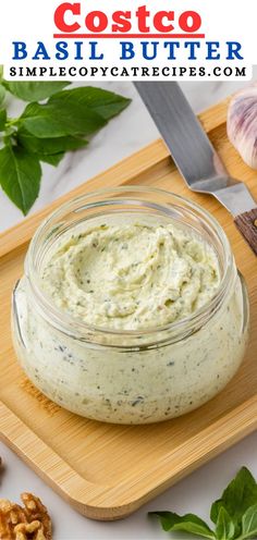 a small glass jar filled with pesto butter on top of a cutting board