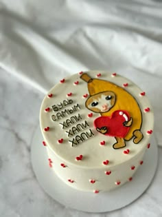 a white cake decorated with an image of a bear holding a heart