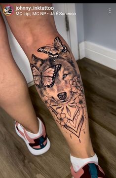 a woman's leg with a tattoo on it that has a wolf and butterflies on it