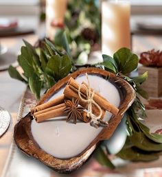 an image of cinnamon sticks and spices on a plate with candles in the background at a table setting