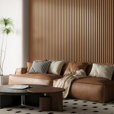 a living room with brown leather couches and pillows