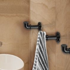 a towel hanging on the wall next to a white sink in a room with beige walls