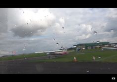 the view from inside an airplane looking out at a runway with raindrops on it