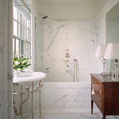 a bath room with a sink a mirror and a bath tub sitting next to a window