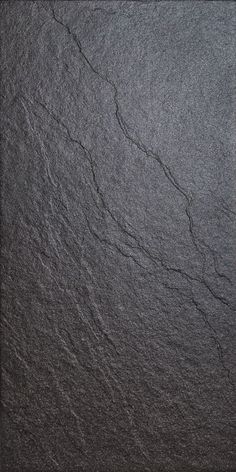 a black slate surface with cracks in the middle and dark gray paint on it's edges