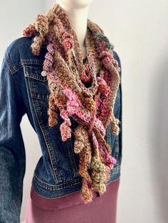 This Rosa scarf has the colors and textures of Fall.  It is a free-form crochet scarf made from various wool blends and synthetic yarns in a beautiful array of soft colors of pinks, beige, camel, greens, purples, rose, gold, and many more. There are lots of very soft hand-spun yarns in this scarf, making it ultra-soft.  There are various splits in the scarf pattern to allow you to pull ends through for more style possibilities.  The video shows how the random breaks in the pattern allow you to pull the scarf through for more styling possibilities.  It is about 72 inches long/ and varies between 3,5-4.5  inches wide (varies throughout the scarf) and can be used to create many different looks.   NOTE: The 2024 scarf collection celebrates remarkable women by naming each scarf after a specific Pink Bohemian Scarves For Fall, Pink Shawl For Fall, Pink Bohemian Scarf For Fall, Hand Knitted Multicolor Scarves For Fall, Fall Multicolor Crochet Scarf, Pink Bohemian Scarf One Size, Bohemian Pink Shawl For Winter, Pink Bohemian Shawl For Winter, Winter Bohemian Pink Shawl