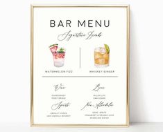 the bar menu is displayed on a white table with a gold frame and two glasses filled with drinks