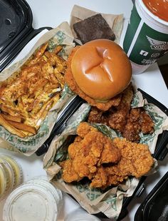 two trays filled with different types of food on top of a white table next to drinks