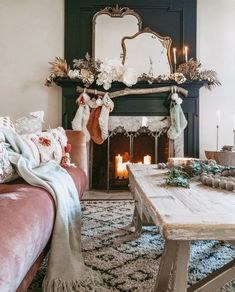 a living room filled with furniture and a fire place in front of a christmas tree