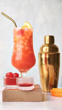 a tall glass filled with liquid and garnished with an orange slice