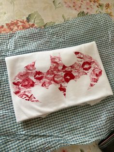 a white towel with a red bat on it sitting on top of a blue and white checkered table cloth