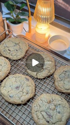 chocolate chip cookies cooling on a wire rack next to a lamp and potted plant