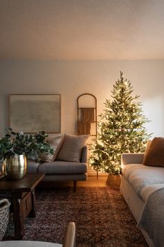 a living room filled with furniture and a christmas tree in the middle of the room