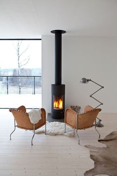 a living room with two chairs and a fire place in the middle of the room