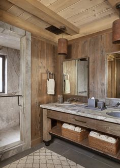 a bathroom with wooden walls and two sinks