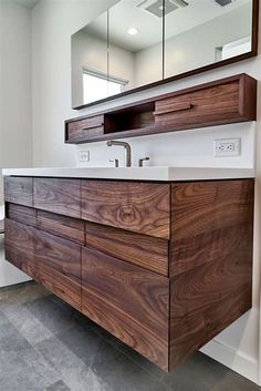 a bathroom with a large mirror above the sink and wooden cabinetry on the wall