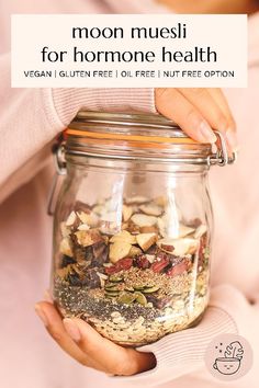 a woman holding a jar full of food with the words moon muesi for hormome health