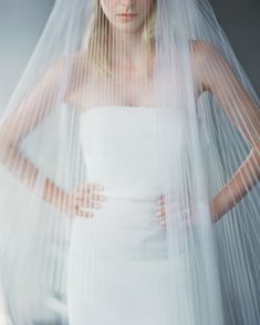 a woman wearing a white wedding dress and veil