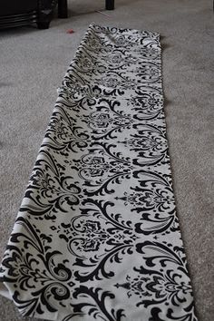 a black and white table runner sitting on top of a carpeted floor in a living room