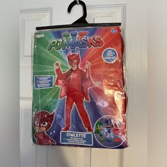 the package is hanging on the door and has an image of a person in a red costume