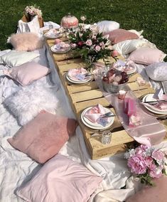 a picnic table set up with pink and white pillows