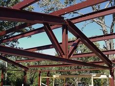 the inside of a building that is being constructed with metal beams and wood planks