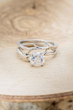 a close up of a ring on top of a tree stump with a diamond in the center