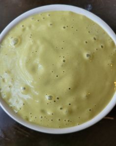 a white bowl filled with yellow liquid on top of a table