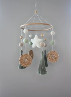 a mobile that is hanging from the ceiling with balls and tassels on it