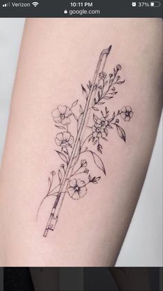 a black and white photo of a flower on the side of a woman's thigh