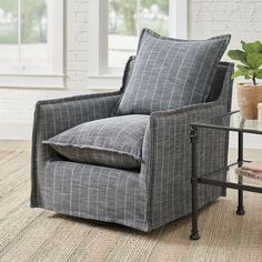 a gray chair sitting next to a table with a potted plant on top of it