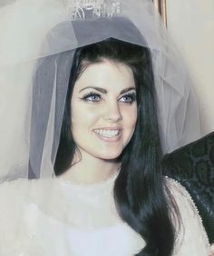 a woman with long black hair wearing a veil