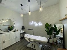 a salon with white chairs and lights on the wall