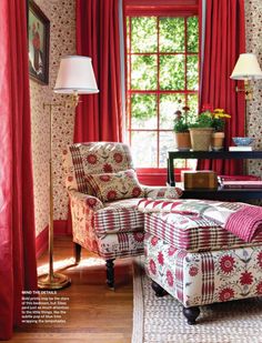 a living room with red curtains and plaid furniture in the corner, along with a large window