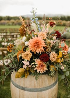 a wooden barrel filled with lots of flowers