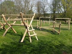 a wooden structure made out of logs in the grass