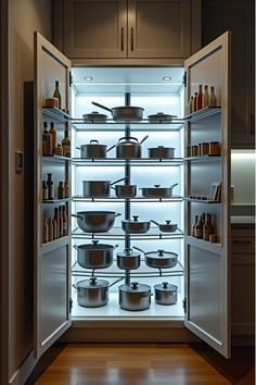 an open refrigerator with many pots and pans in it's door, showing the light coming through