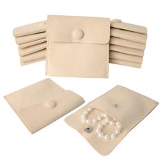 six pairs of pearls are laid out on top of a white cloth pouch with buttons