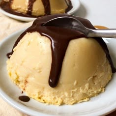 a scoop of ice cream on top of a white plate with chocolate drizzle