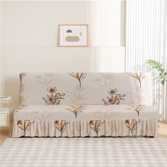 a living room with a white couch covered in a flowered design and matching curtains