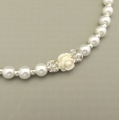 a white necklace with flowers and pearls