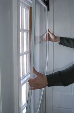 a woman is opening the window with her hands