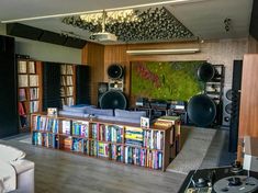 a living room filled with lots of books and audio equipment