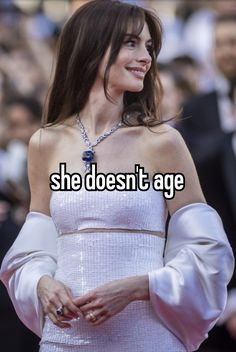 a woman in a white dress with the caption, she doesn't age