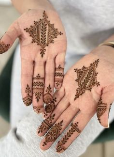 two hands with henna tattoos on them