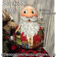 santa and gifts painted on an egg next to a teddy bear