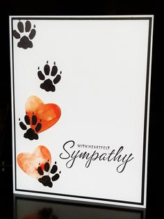 a card with paw prints and the words sympathy written in black ink on white paper